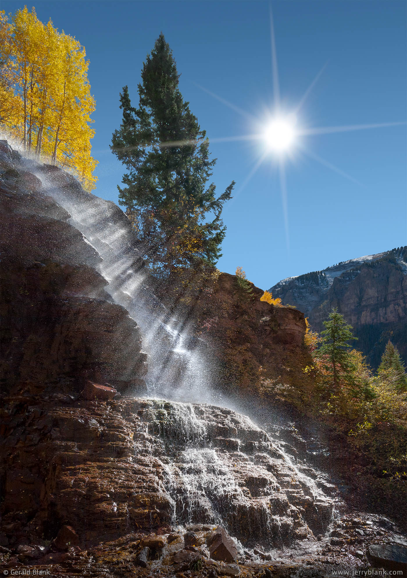 #06918 - Water sprayed from a flume above Marshall Creek is caught by the rays of the sun, outside of Telluride, Colorado - photo by Jerry Blank