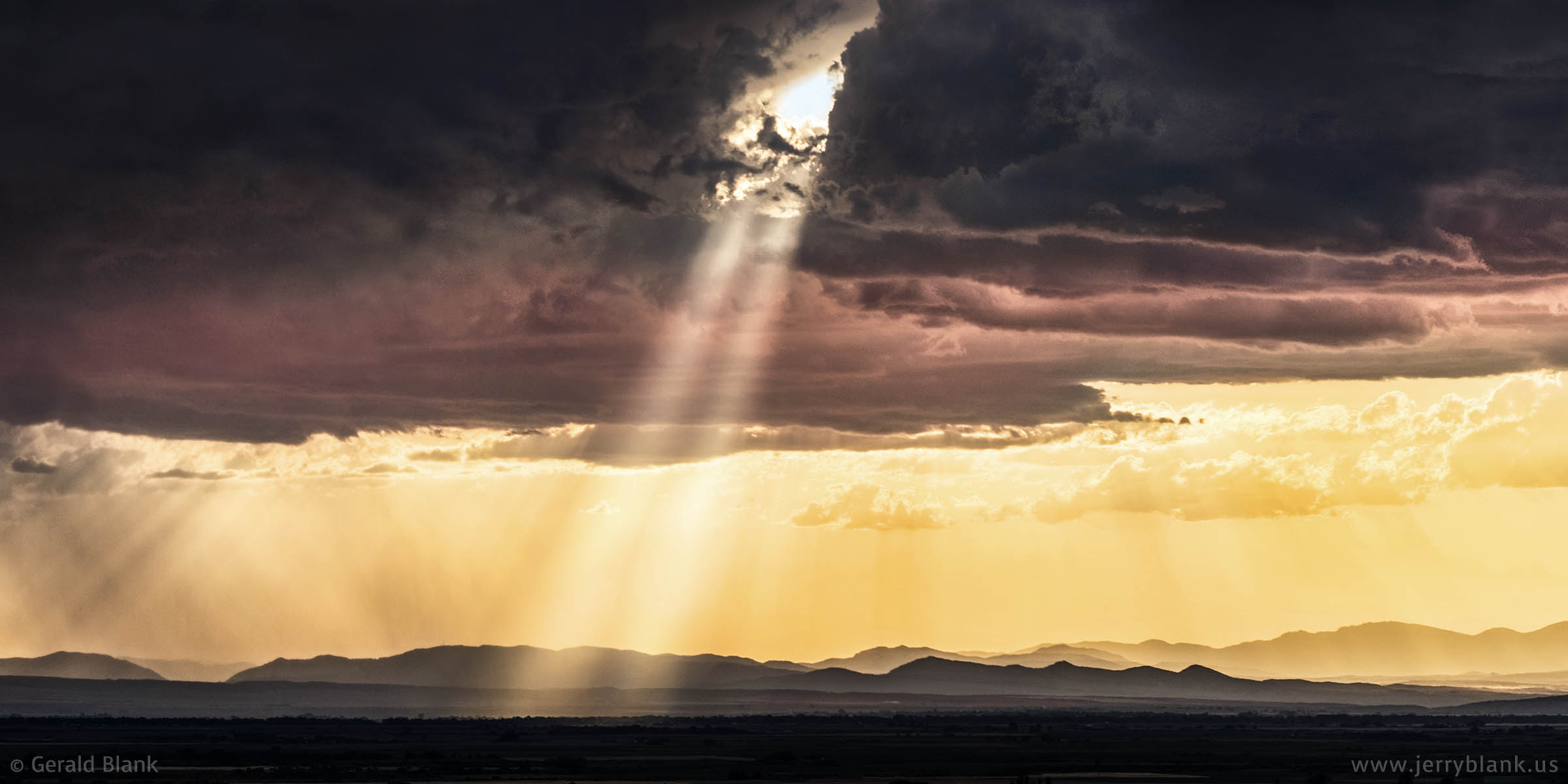 #10196 - Rays of sunlight pierce a storm cloud above the Gallatin Valley in western Montana - photo by Jerry Blank