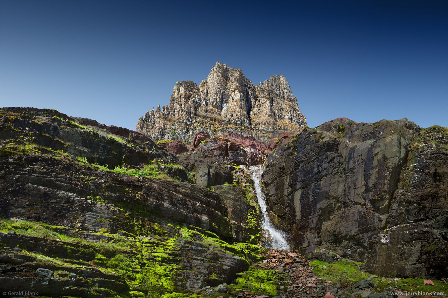 #26276 - Clements Mountain rises above moss-covered slopes and a waterfall on the east side of the Continental Divide, in Glacier National Park, Montana - photo by Jerry Blank