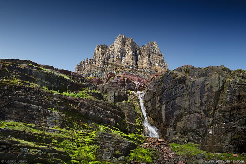 #26276 - Clements Mountain rises above moss-covered slopes and a waterfall on the east side of the Continental Divide, in Glacier National Park, Montana - photo by Jerry Blank